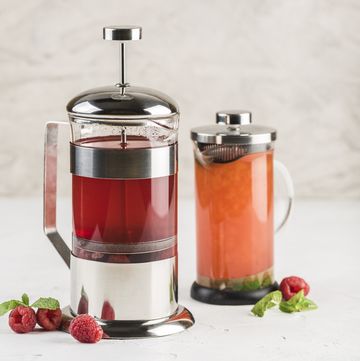 french press with tea from different berries